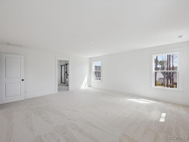 spare room with carpet, baseboards, and visible vents
