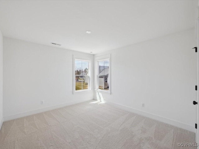 empty room with carpet, baseboards, and visible vents