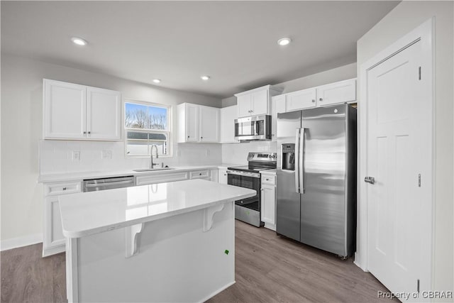 93 Grace Hill Cir, Kilmarnock, VA 22482 - kitchen featuring stainless steel appliances, a center island, a sink, tasteful backsplash, and white cabinetry