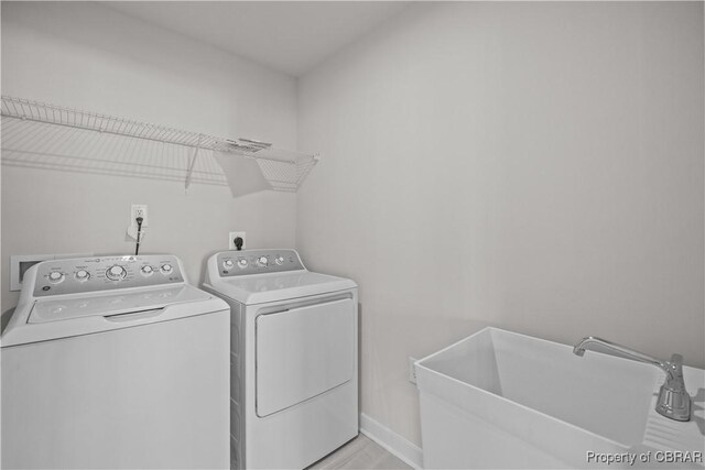 93 Grace Hill Cir, Kilmarnock, VA 22482 - clothes washing area with light wood-style flooring, a sink, baseboards, independent washer and dryer, and laundry area