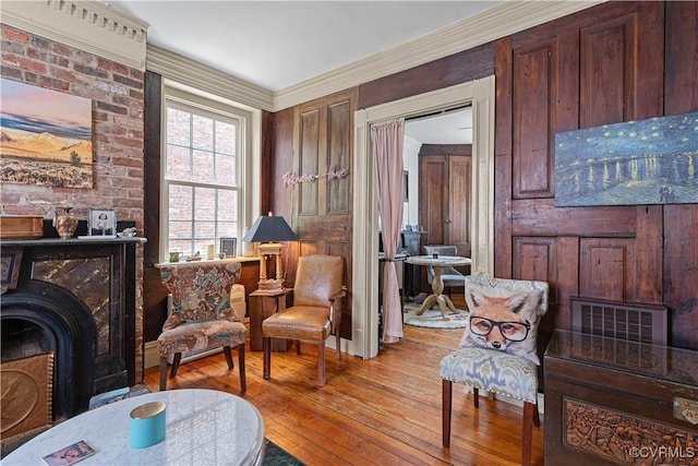 2515 E Grace St, Richmond, VA 23223 - sitting room featuring visible vents, ornamental molding, a wood stove, and hardwood / wood-style flooring