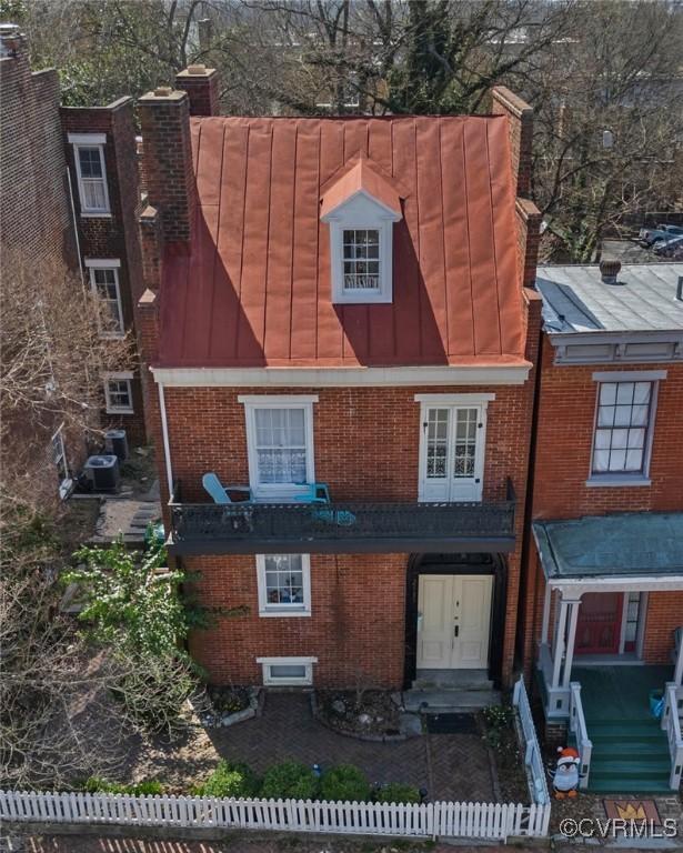 2515 E Grace St, Richmond, VA 23223 - view of front of home with brick siding, a chimney, and a fenced front yard
