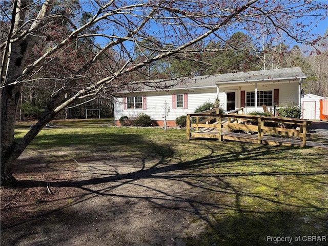 view of front of home featuring a storage unit, an outbuilding, and a front lawn