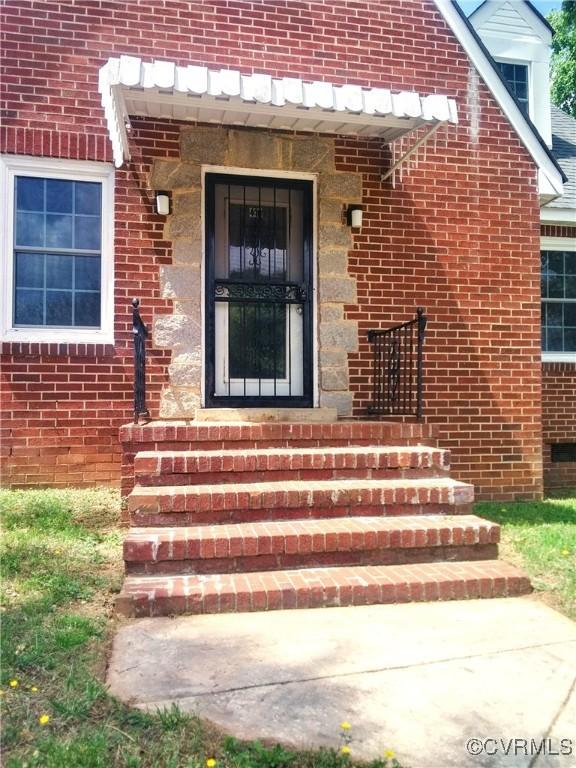 property entrance featuring brick siding