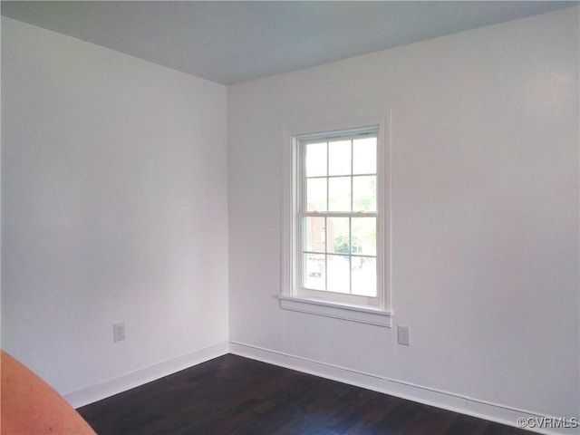 empty room with baseboards and dark wood-style flooring