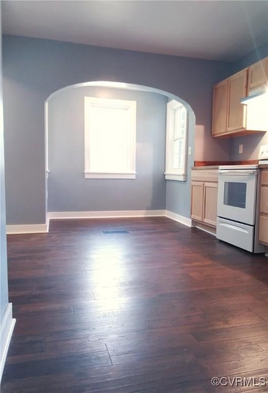 kitchen featuring arched walkways, visible vents, baseboards, white range with electric cooktop, and dark wood-type flooring