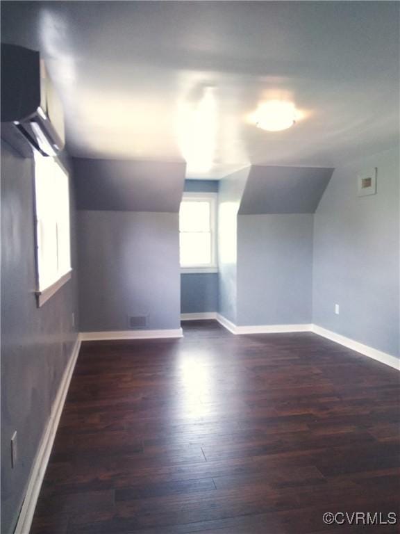 additional living space featuring baseboards, lofted ceiling, and wood finished floors