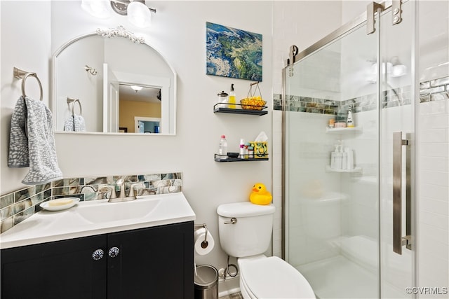 bathroom featuring toilet, a shower stall, and vanity