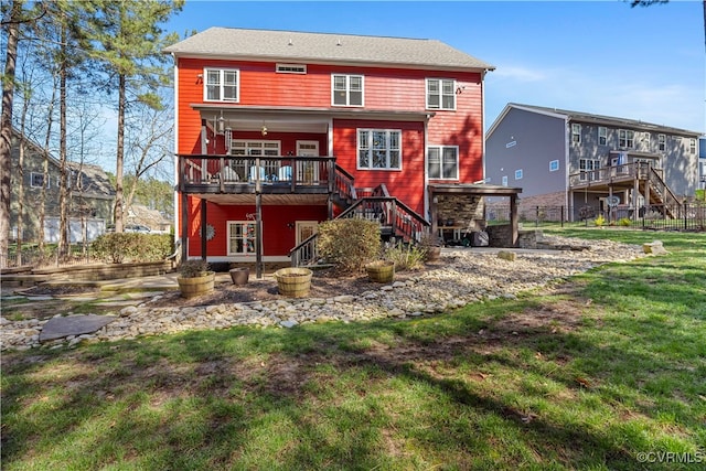 back of house featuring stairway, fence, a wooden deck, and a lawn