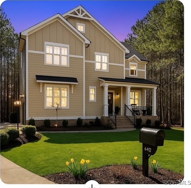 craftsman house featuring a porch, a lawn, and board and batten siding