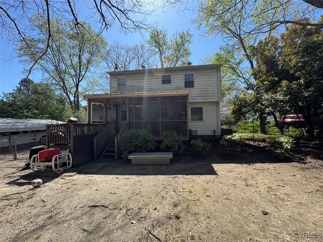 rear view of property with fence and a sunroom