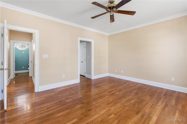 empty room with crown molding, baseboards, wood finished floors, and a ceiling fan