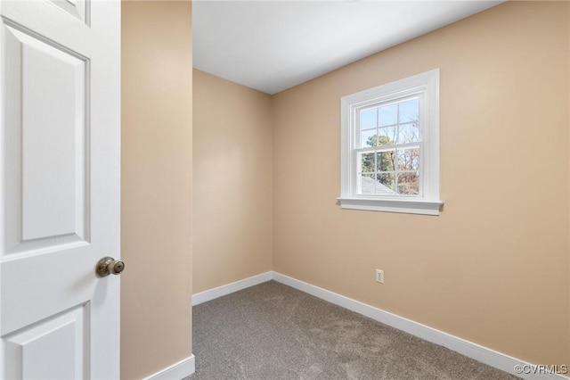 carpeted empty room featuring baseboards