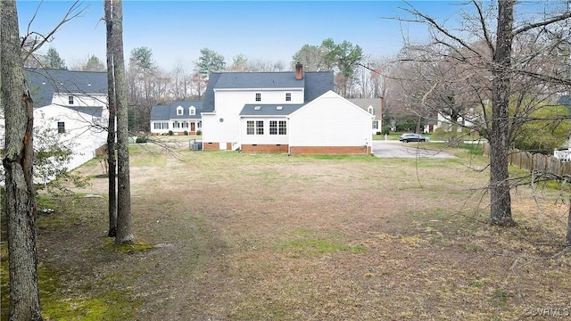 rear view of house with crawl space, a yard, and a chimney