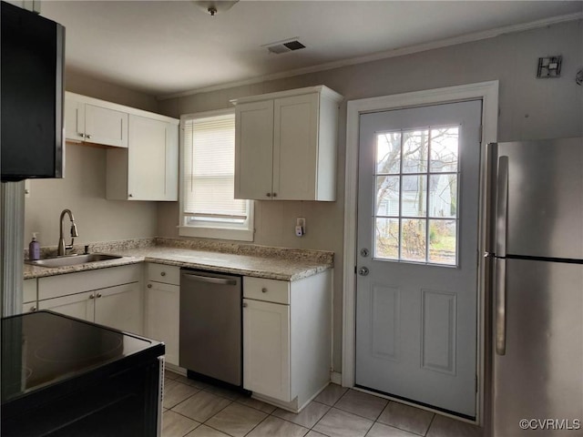 kitchen with a sink, a wealth of natural light, white cabinets, and stainless steel appliances