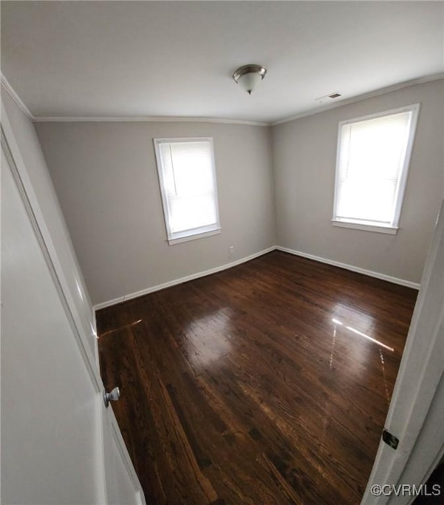 empty room with crown molding, visible vents, and a wealth of natural light