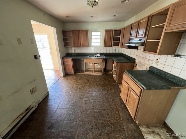 1090 Dry Bread Rd, Emporia, VA 23847 - kitchen with open shelves, tasteful backsplash, brown cabinets, baseboard heating, and under cabinet range hood