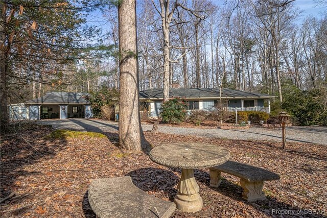59 Hickory Rd, Mollusk, VA 22503 - ranch-style house with a chimney, view of scattered trees, and a porch