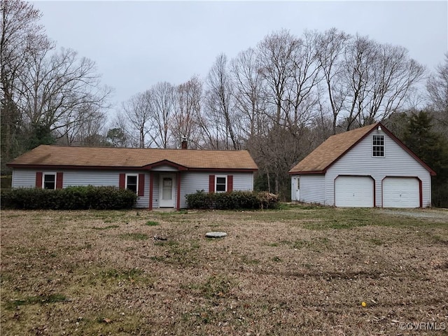view of front of home featuring a garage, an outdoor structure, and a front yard