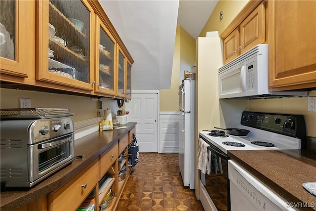 2200 E Grace St, Richmond, VA 23223 - kitchen with dark floors, a toaster, vaulted ceiling, white appliances, and brown cabinetry