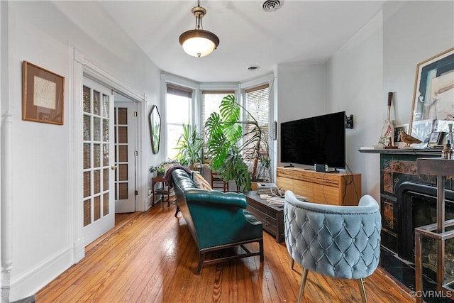 2200 E Grace St, Richmond, VA 23223 - living area featuring a high end fireplace, baseboards, hardwood / wood-style floors, and visible vents
