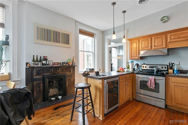 2200 E Grace St, Richmond, VA 23223 - kitchen with stainless steel electric range, wine cooler, under cabinet range hood, and dark countertops