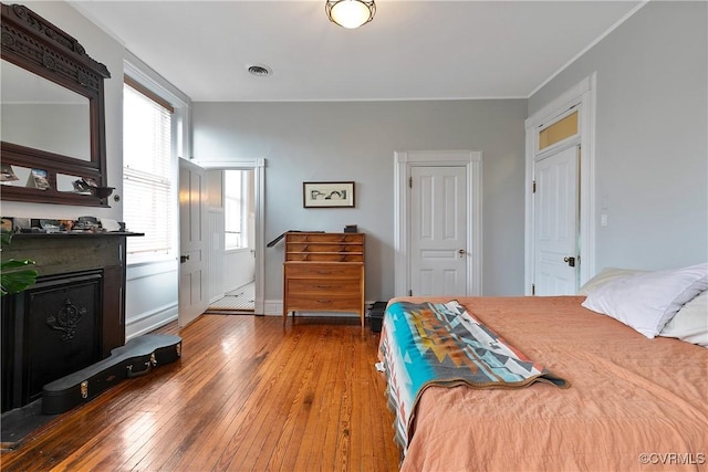 2200 E Grace St, Richmond, VA 23223 - bedroom featuring hardwood / wood-style floors, baseboards, visible vents, and a fireplace