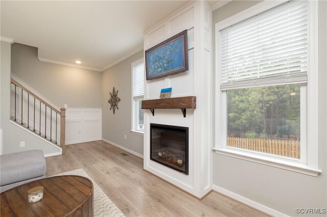 7324 Bailie Dr, Mechanicsville, VA 23111 - unfurnished living room featuring stairs, ornamental molding, wood finished floors, a wealth of natural light, and a glass covered fireplace