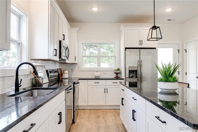 8031 Lake Shore Dr, North Chesterfield, VA 23235 - kitchen with backsplash, a sink, white cabinetry, and appliances with stainless steel finishes