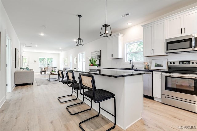 8031 Lake Shore Dr, North Chesterfield, VA 23235 - kitchen featuring a breakfast bar, open floor plan, stainless steel appliances, visible vents, and decorative backsplash