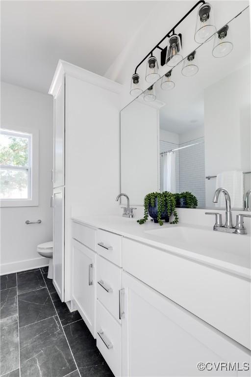 8031 Lake Shore Dr, North Chesterfield, VA 23235 - bathroom featuring toilet, baseboards, marble finish floor, a sink, and double vanity