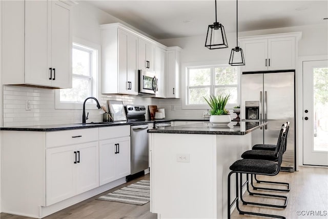 8031 Lake Shore Dr, North Chesterfield, VA 23235 - kitchen featuring a kitchen bar, stainless steel appliances, a kitchen island, white cabinetry, and a sink
