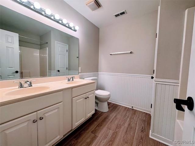 14312 Ashdale Way, Chesterfield, VA 23832 - full bathroom featuring wood finished floors, a wainscoted wall, double vanity, toilet, and a shower
