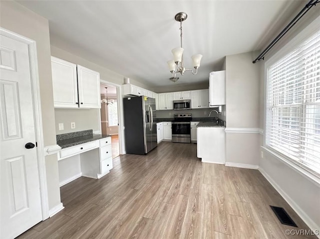 14312 Ashdale Way, Chesterfield, VA 23832 - kitchen with stainless steel appliances, a chandelier, wood finished floors, dark countertops, and white cabinets