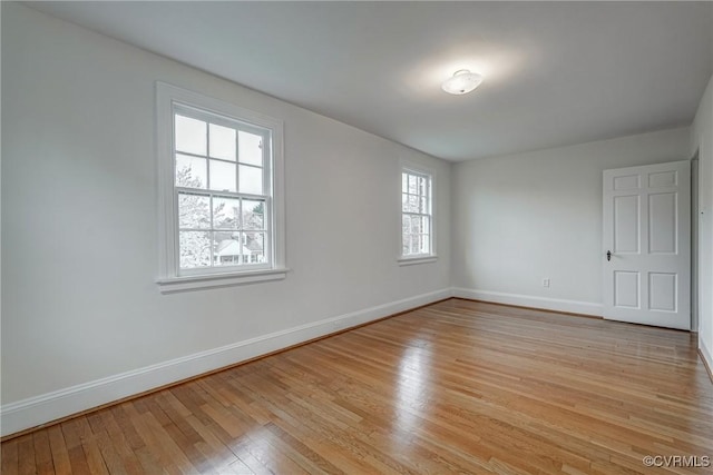 unfurnished room featuring baseboards and light wood finished floors