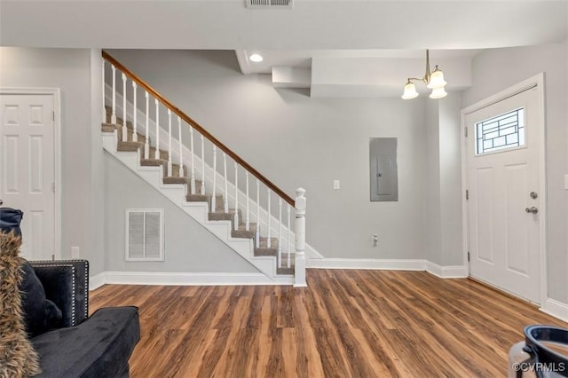 foyer entrance featuring visible vents, wood finished floors, electric panel, and stairway