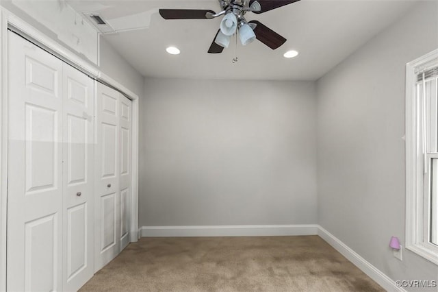 unfurnished bedroom featuring baseboards, a closet, and light carpet