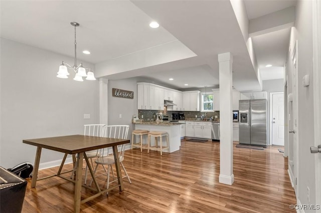 dining room with recessed lighting, an inviting chandelier, and wood finished floors