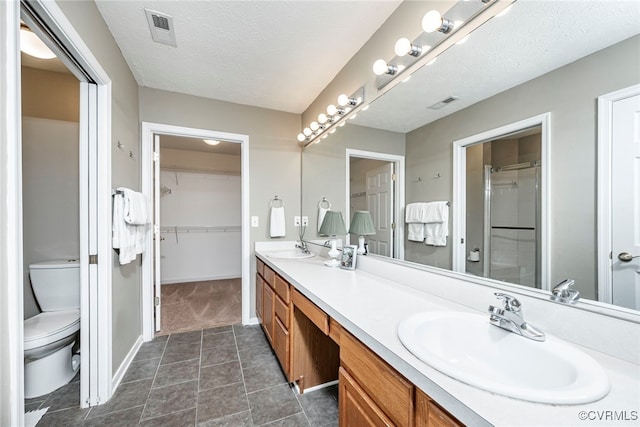 2404 Wanstead Ct, Henrico, VA 23238 - full bathroom with toilet, a stall shower, double vanity, a textured ceiling, and a walk in closet