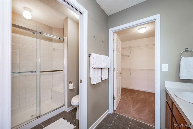2404 Wanstead Ct, Henrico, VA 23238 - bathroom with a shower stall, toilet, vanity, a walk in closet, and a textured ceiling