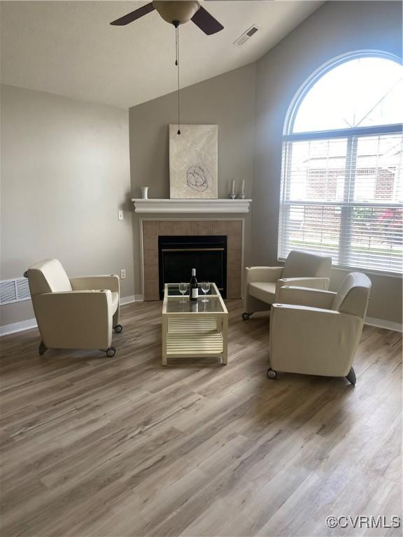 2404 Wanstead Ct, Henrico, VA 23238 - sitting room featuring lofted ceiling, a ceiling fan, plenty of natural light, a tiled fireplace, and wood finished floors