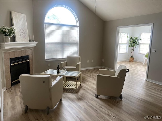2404 Wanstead Ct, Henrico, VA 23238 - living area featuring light wood-style floors, vaulted ceiling, baseboards, and a tiled fireplace