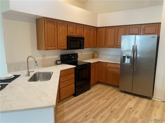2404 Wanstead Ct, Henrico, VA 23238 - kitchen with black appliances, a sink, a peninsula, light wood-type flooring, and brown cabinets