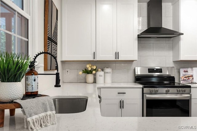 kitchen featuring backsplash, white cabinets, wall chimney exhaust hood, and electric stove