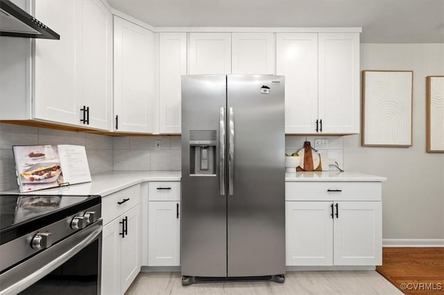 kitchen with white cabinets, under cabinet range hood, light countertops, stainless steel appliances, and decorative backsplash