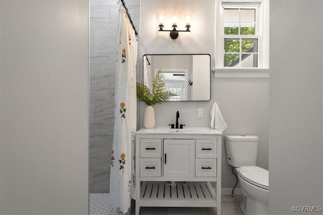 full bathroom featuring toilet, vanity, and a tile shower