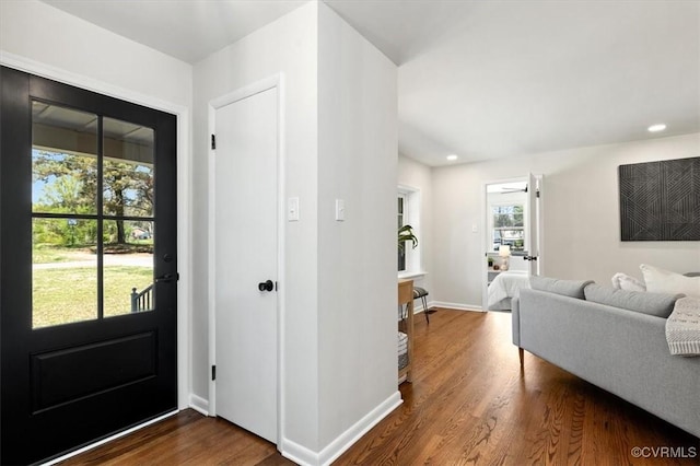 entrance foyer with dark wood-style flooring, baseboards, and a healthy amount of sunlight