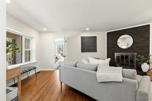 living room with baseboards, recessed lighting, wood finished floors, and a fireplace