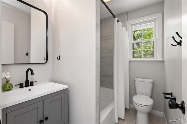 bathroom featuring shower / bathtub combination with curtain, vanity, toilet, wood finished floors, and baseboards