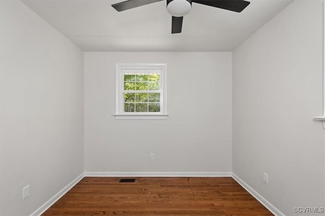 spare room with visible vents, ceiling fan, wood finished floors, and baseboards